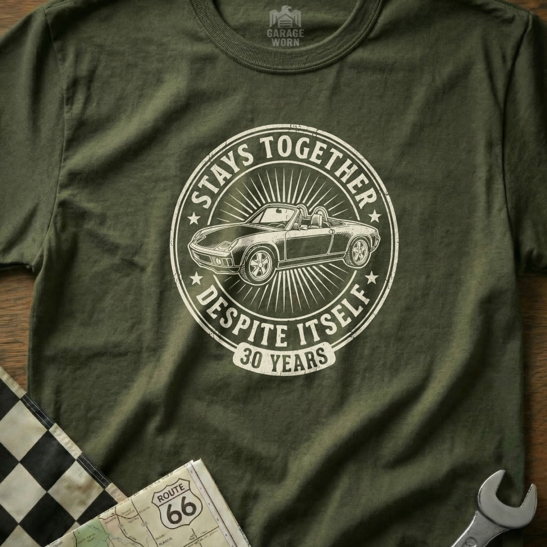 Olive green t-shirt with distressed graphic of a convertible car and "Stays Together Despite Itself 30 Years".