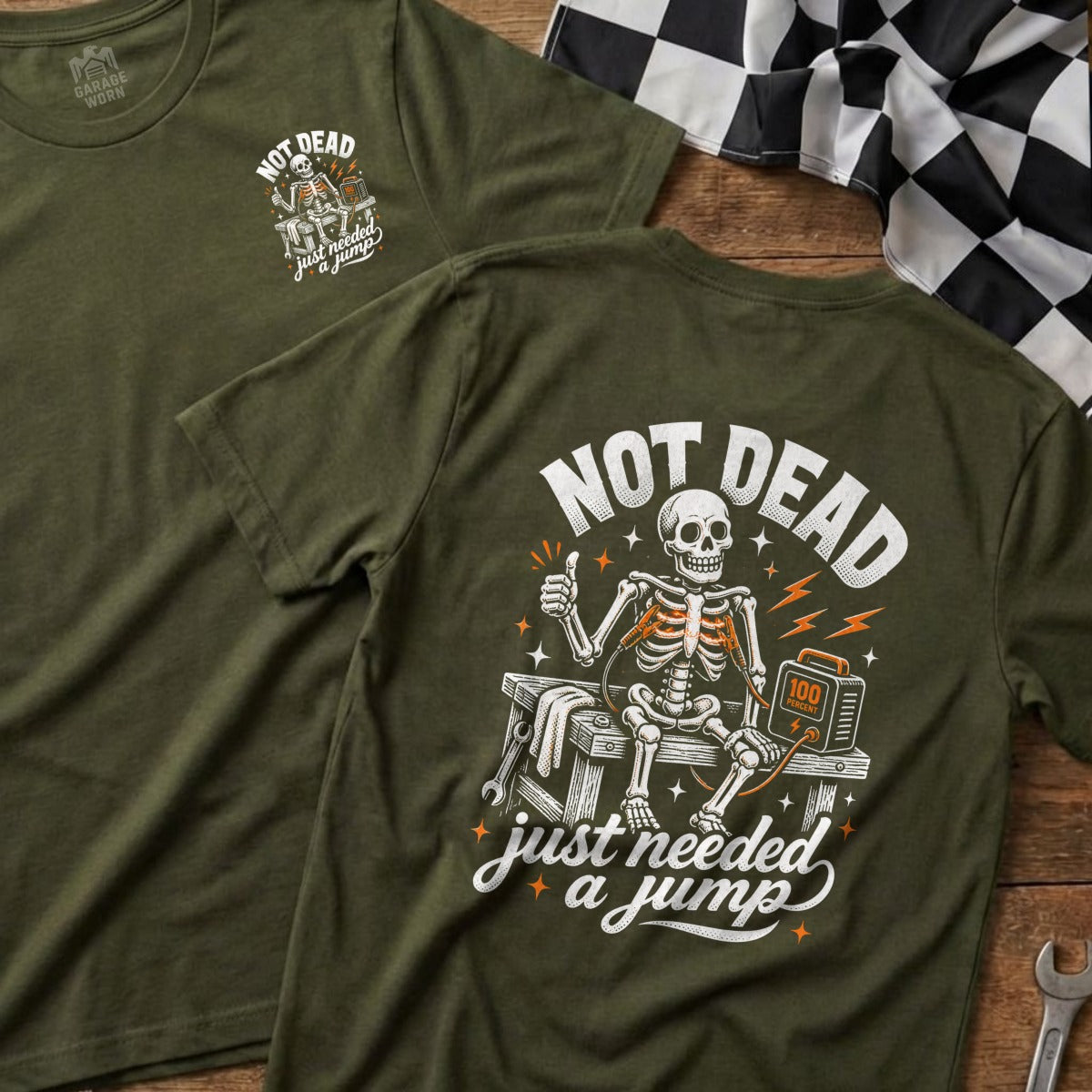 Green t-shirt with skeleton "Not Dead, Just Needed a Jump" graphic.