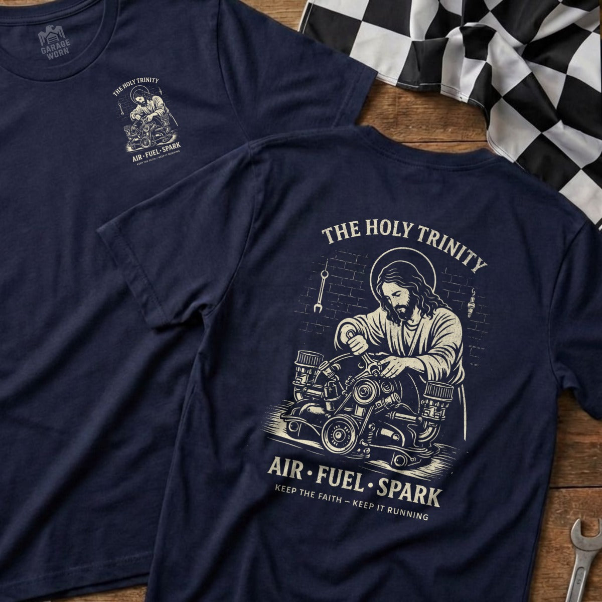 Navy t-shirt with Jesus working on an engine, "The Holy Trinity Air-Fuel-Spark" text.