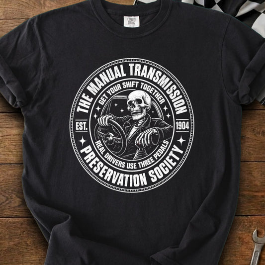 Black t-shirt featuring a skeleton driving and the text "The Manual Transmission Preservation Society."