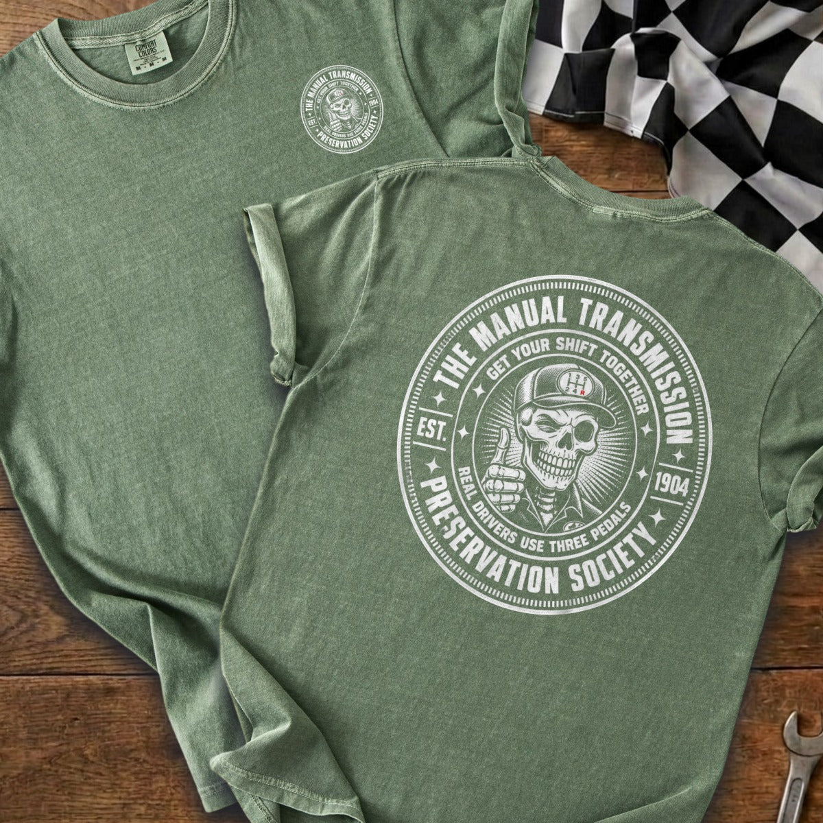 Green t-shirt with a circular graphic of a skeleton giving a thumbs-up.