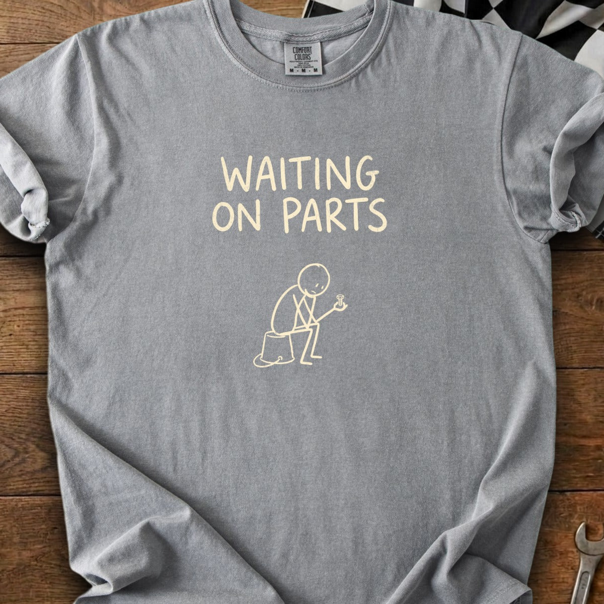 Gray t-shirt with "WAITING ON PARTS" text and stick figure holding a bolt.