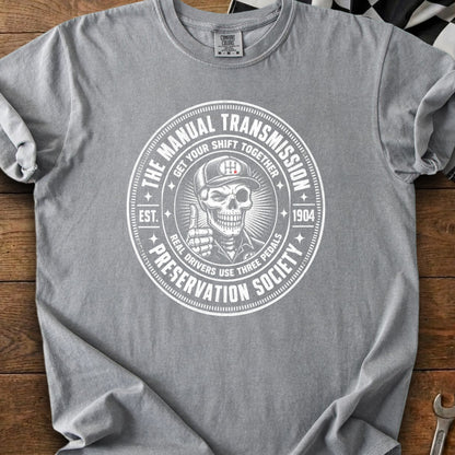 Grey t-shirt with circular graphic: "The Manual Transmission Preservation Society" with a skeleton.