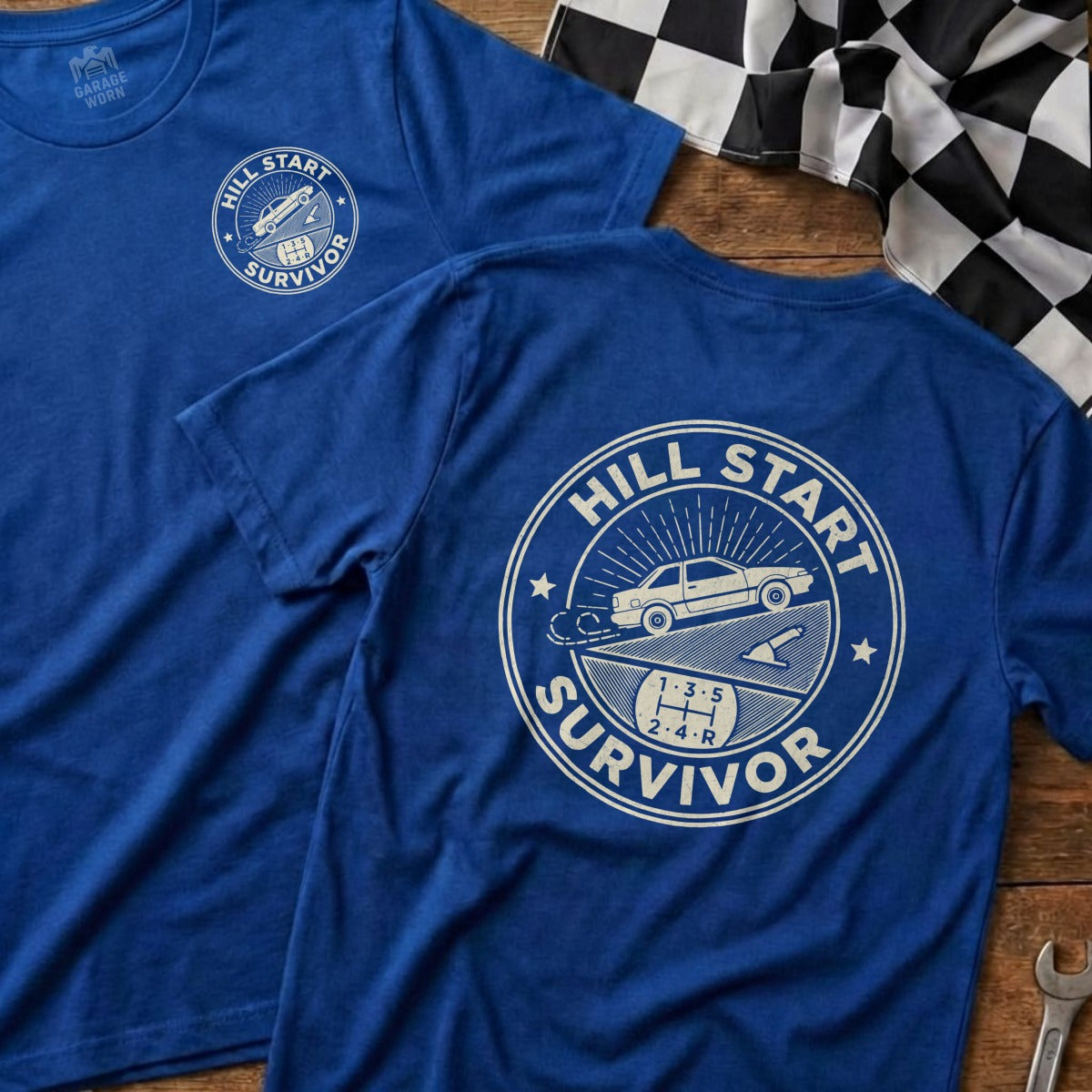 Blue t-shirt with "Hill Start Survivor" text and car graphic on back.