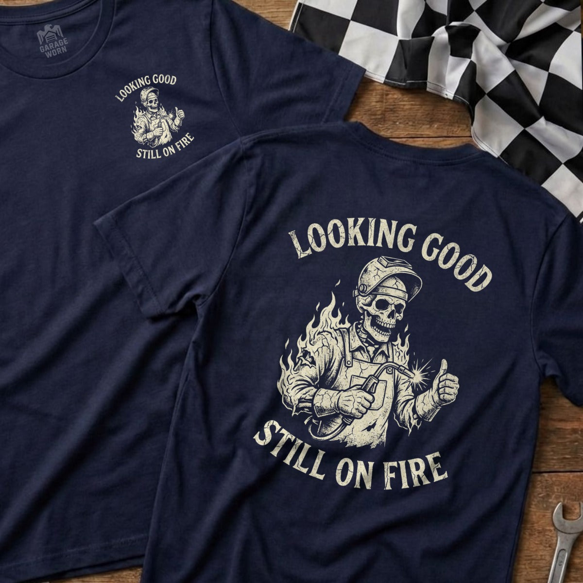 Navy t-shirt with skeleton welder and "Looking Good Still On Fire" text.