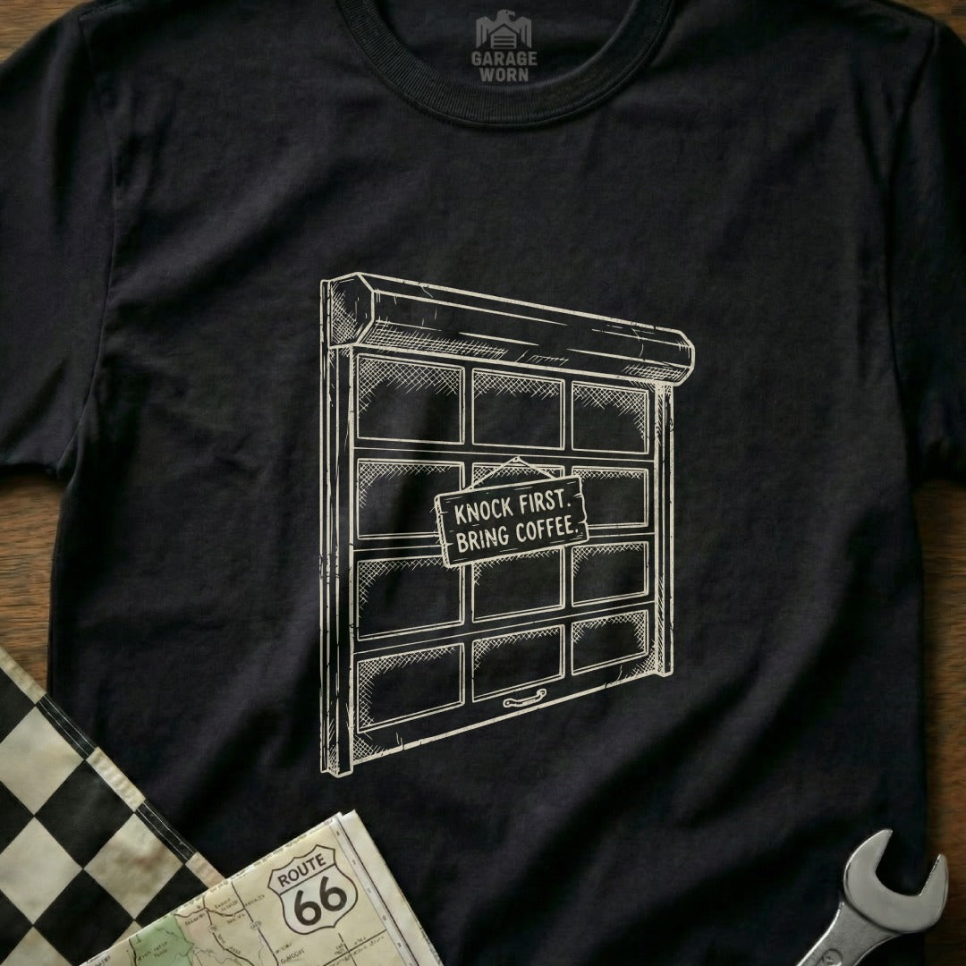 T-shirt with garage door graphic and "Knock First, Bring Coffee" sign.