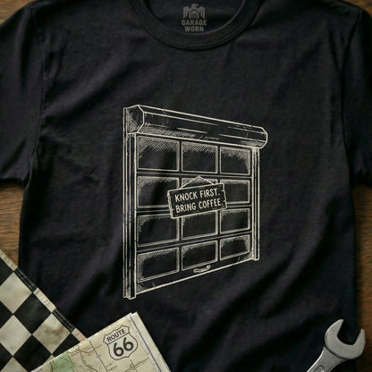 T-shirt with garage door graphic and "Knock First, Bring Coffee" sign.
