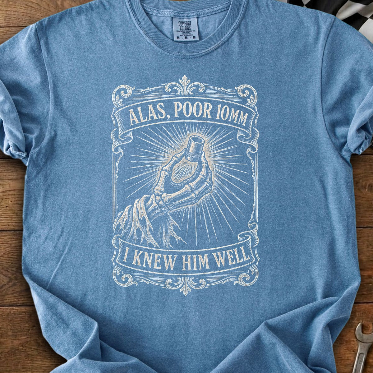 Blue t-shirt with skeleton hand holding a socket and text "Alas, Poor 10mm. I Knew Him Well."