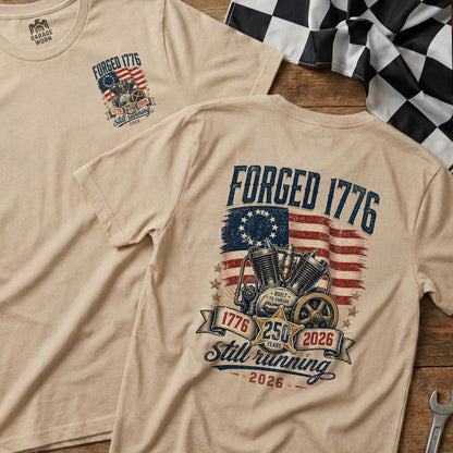 Tan t-shirt with "Forged 1776" graphic featuring a motorcycle engine and American flag.