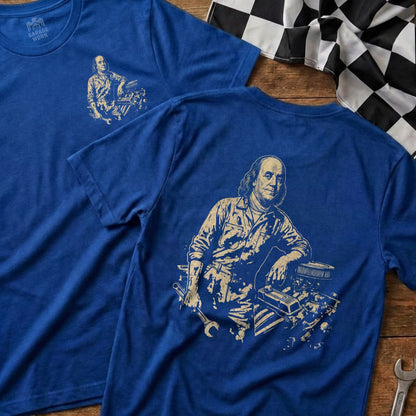 Blue t-shirt with graphic of Benjamin Franklin working on an engine.