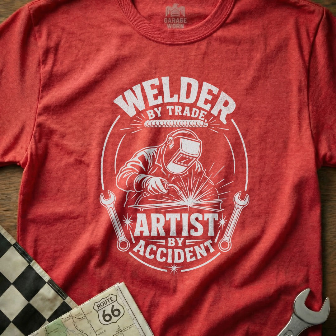 Red t-shirt with graphic: "Welder By Trade Artist By Accident"