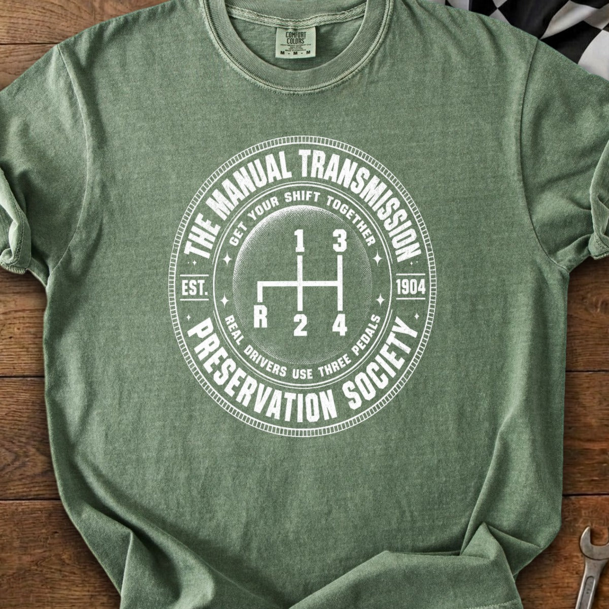 Green t-shirt with manual transmission shift pattern and "Manual Transmission Preservation Society" text.