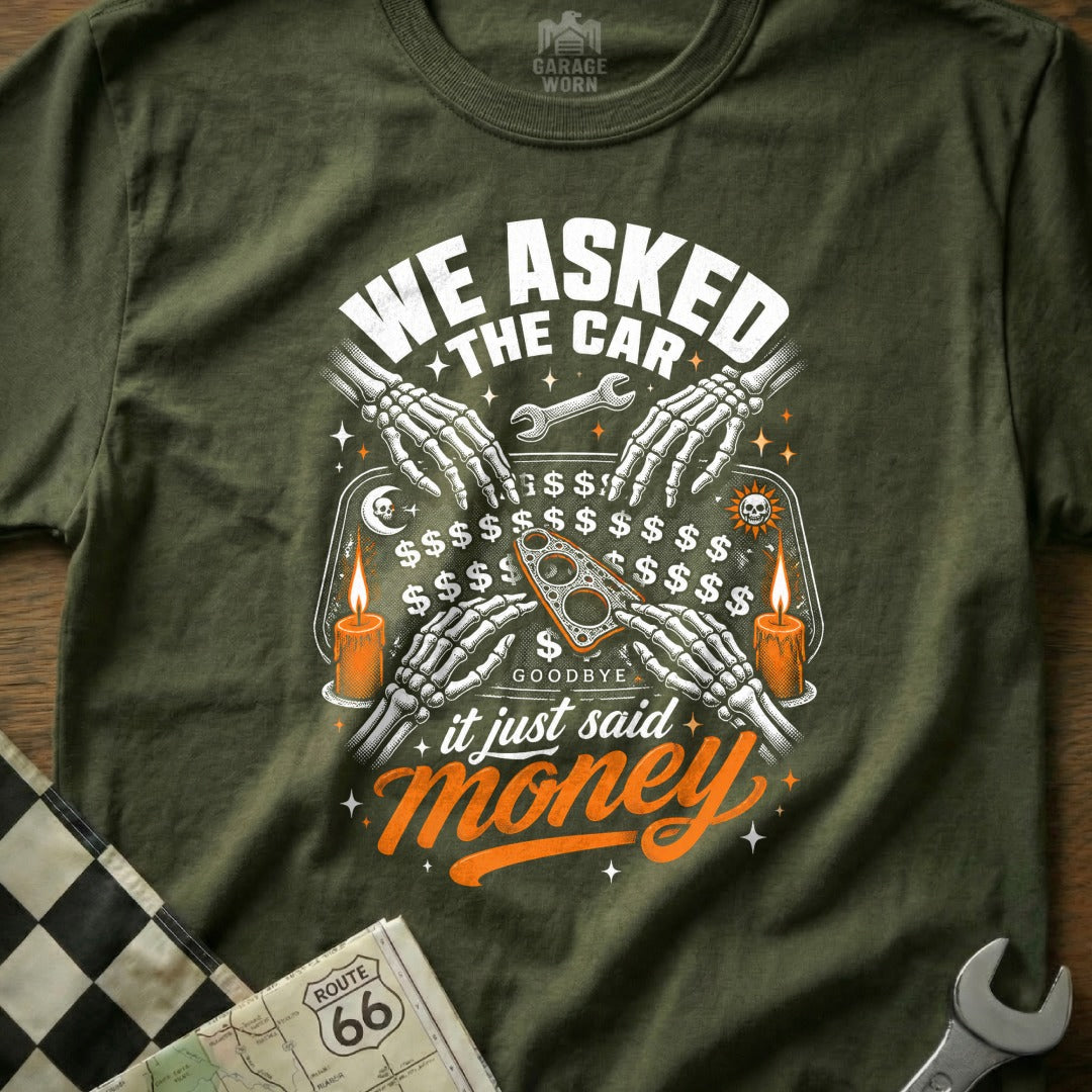 T-shirt with skeleton hands on a Ouija board with "WE ASKED THE CAR" and "it just said money."
