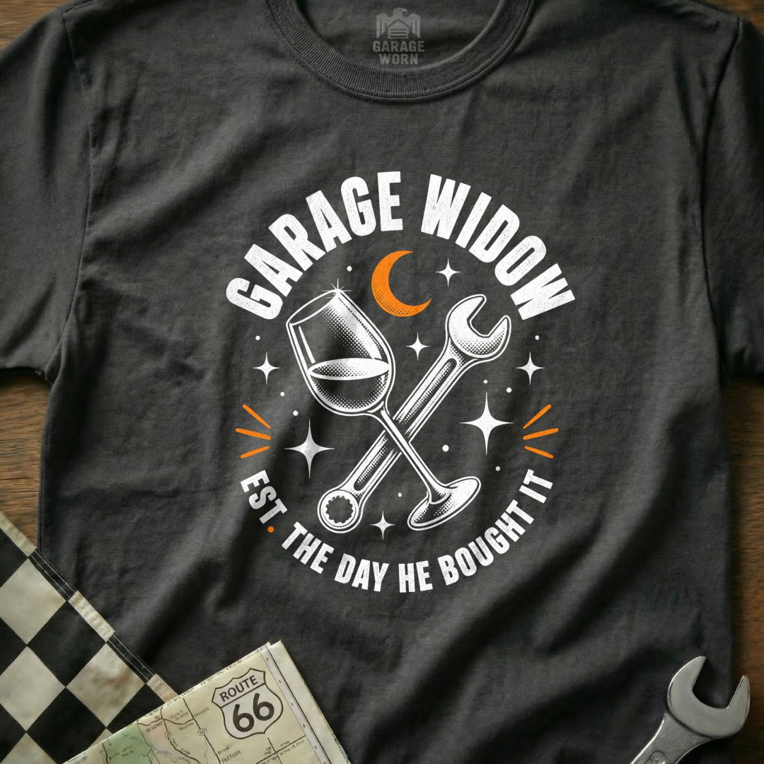 T-shirt with "Garage Widow Est. The Day He Bought It" text, wine glass, and wrench graphic.