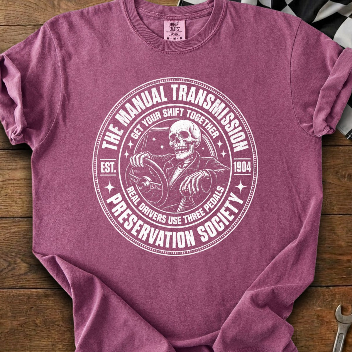 Skeleton driving a manual transmission car, "The Manual Transmission Preservation Society" text.
