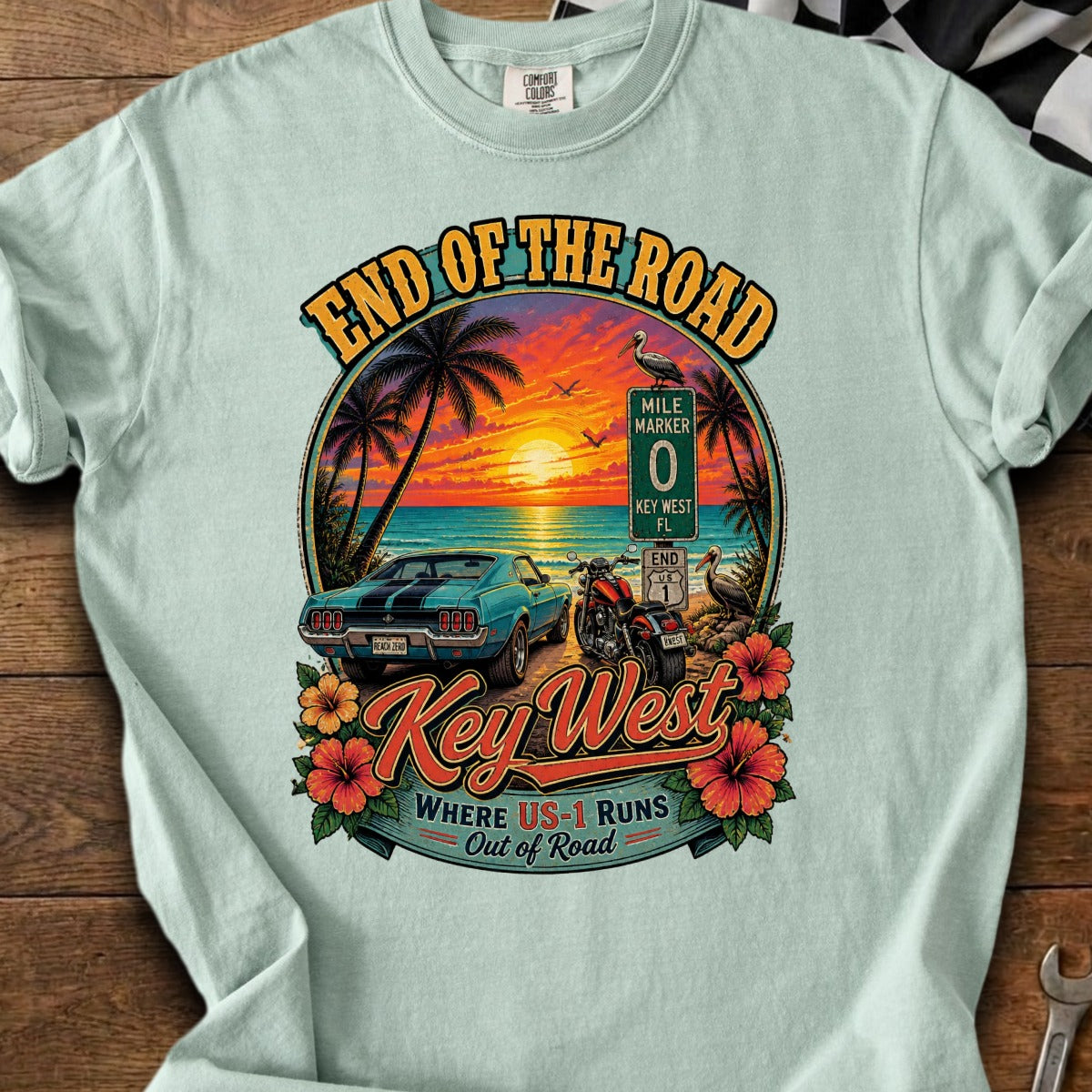 Key West "End of the Road" graphic with a sunset, classic car, motorcycle, and palm trees.