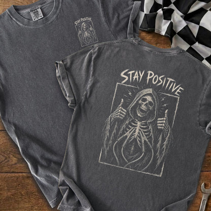 Gray t-shirt with grim reaper giving thumbs up and "STAY POSITIVE" text.