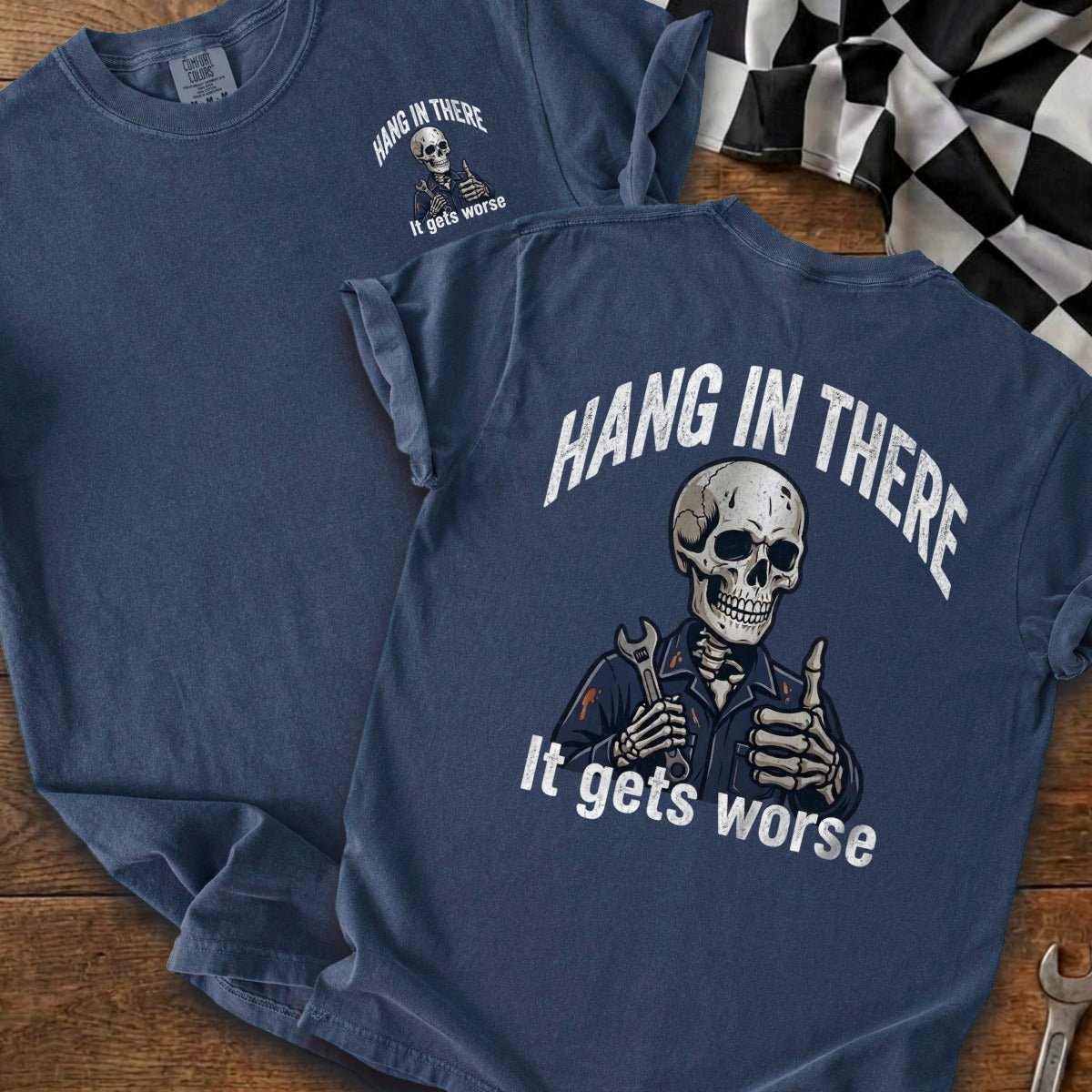 Blue t-shirt with skeleton holding wrench and giving thumbs up, saying "Hang in There. It gets worse."