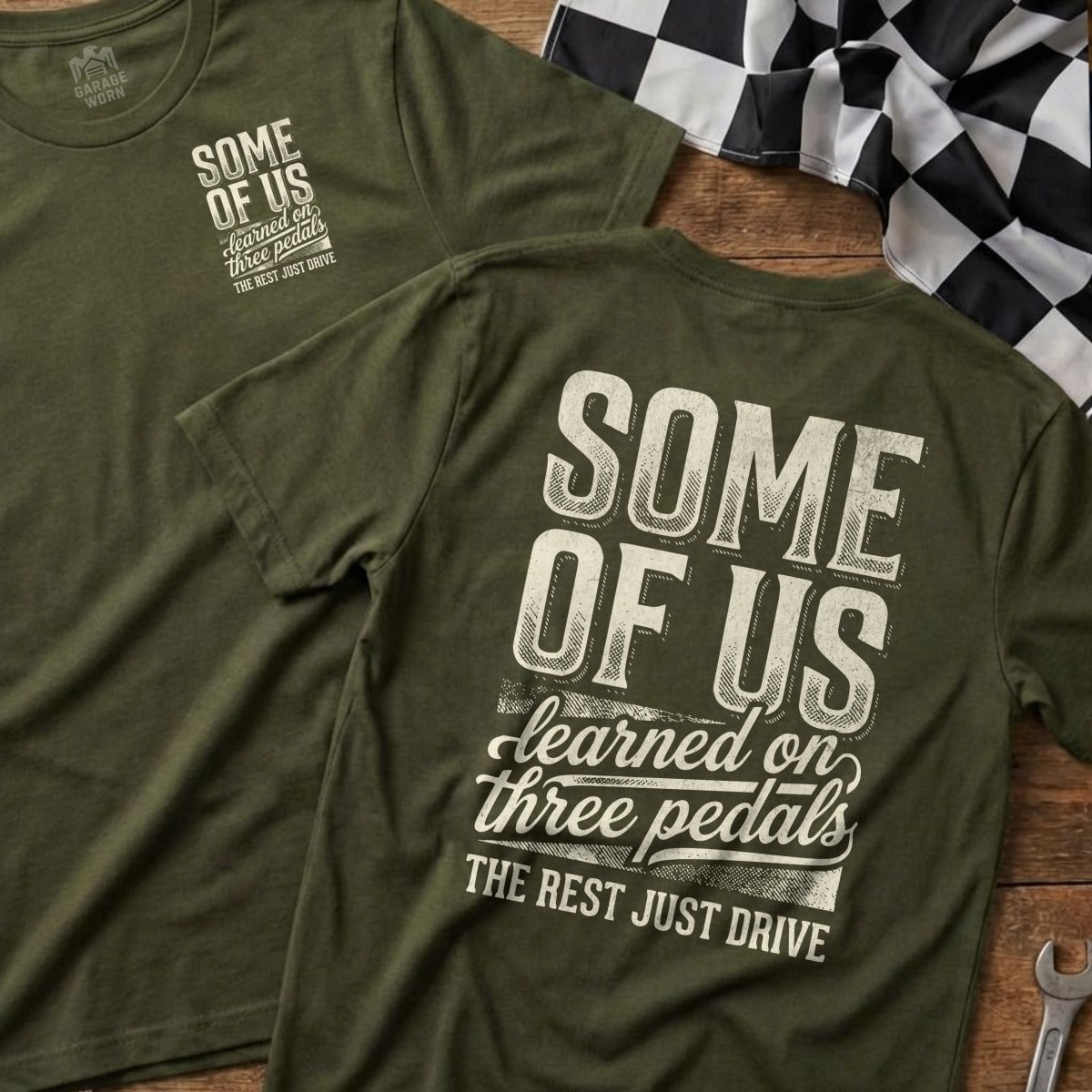 Olive green t-shirt with "Some of us learned on three pedals" text.
