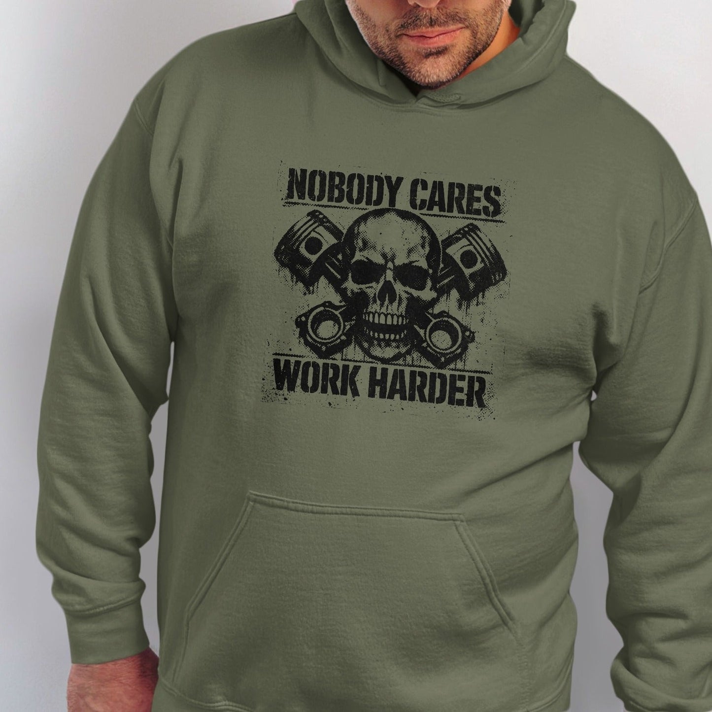 Olive hoodie with a black graphic of a skull and pistons and text "Nobody Cares Work Harder."