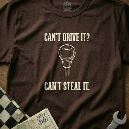 Brown t-shirt with text "CAN'T DRIVE IT? CAN'T STEAL IT." and a gear shift.