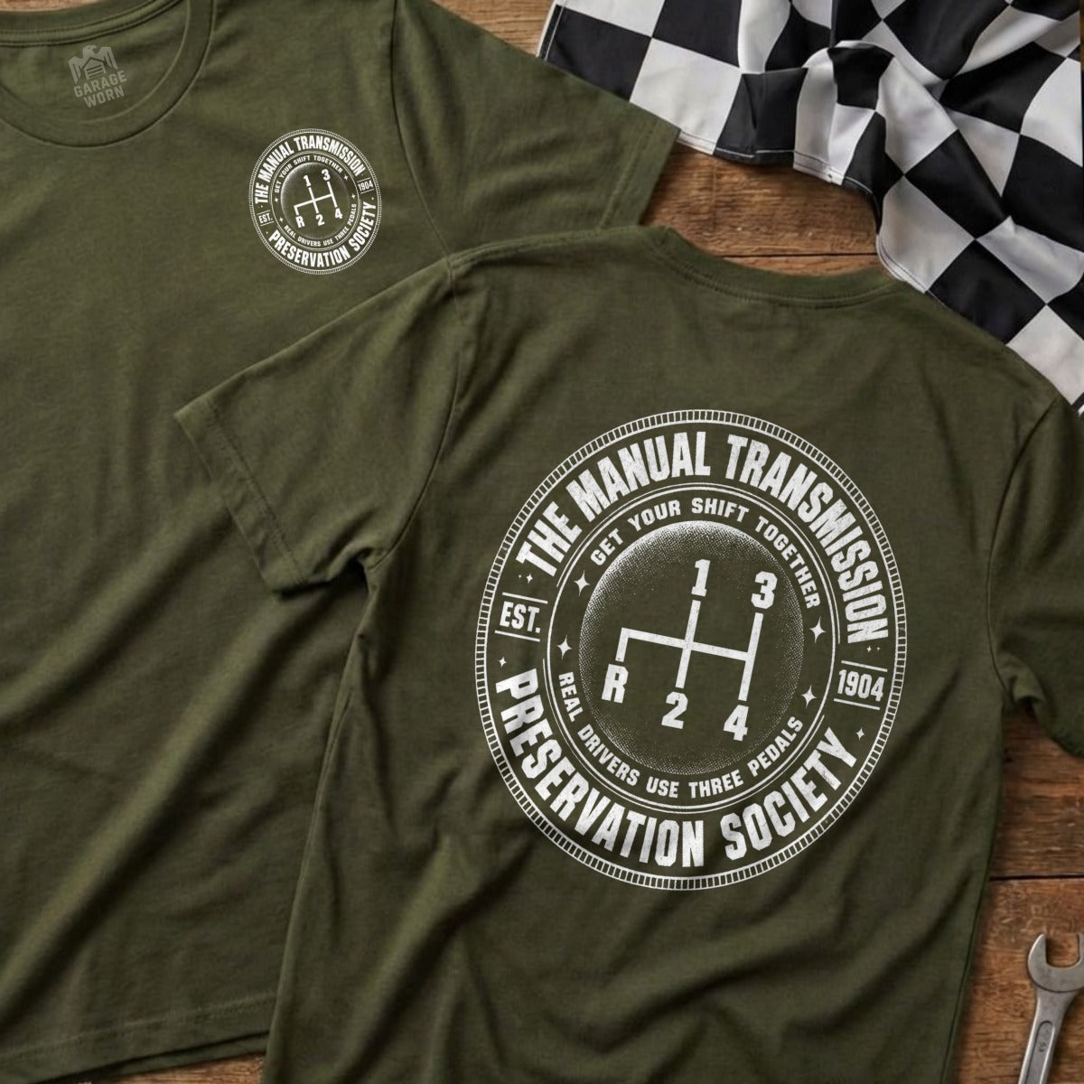 Green t-shirt with "The Manual Transmission Preservation Society" logo and gear shift graphic.
