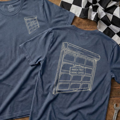 Blue t-shirt with a garage door and text "KNOCK FIRST. BRING COFFEE."