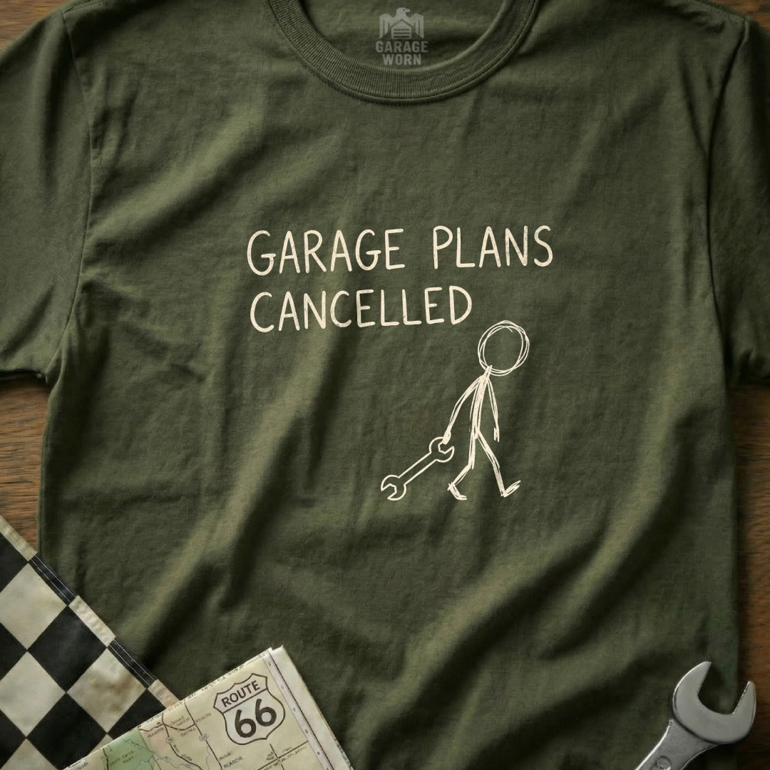 Olive t-shirt with "GARAGE PLANS CANCELLED" text and a stick figure holding a wrench.
