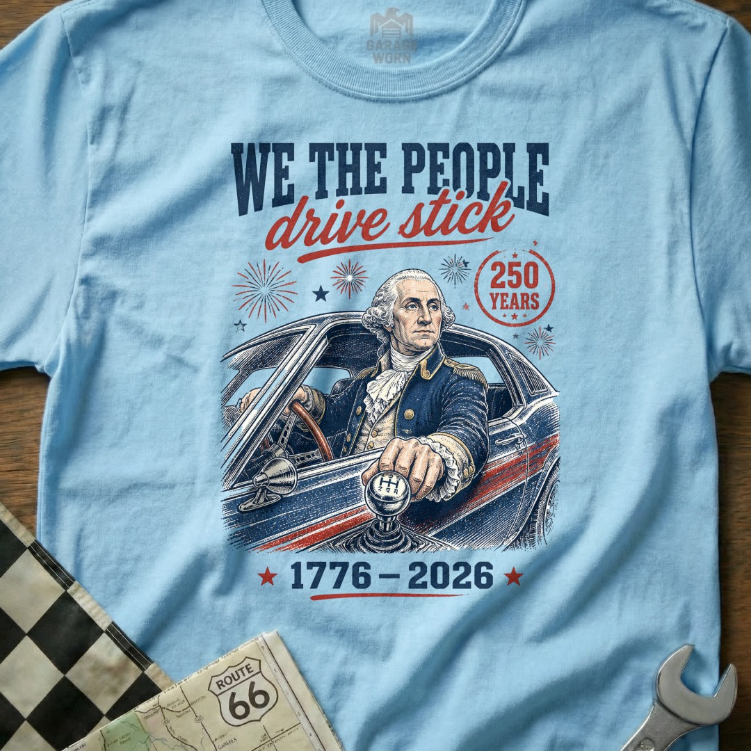 George Washington driving a stick shift car with "We The People Drive Stick" text.