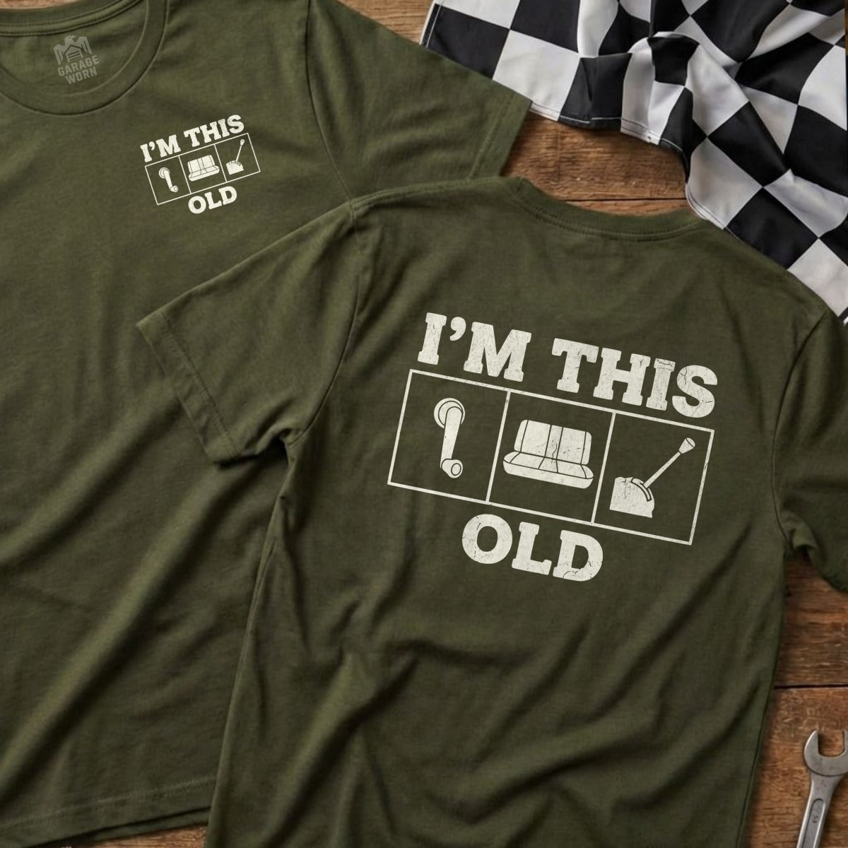 Olive green t-shirt with white text and icons: "I'M THIS OLD" with question mark, couch, and shovel.