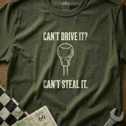 Olive t-shirt with "Can't Drive It? Can't Steal It." text and gear shift graphic.
