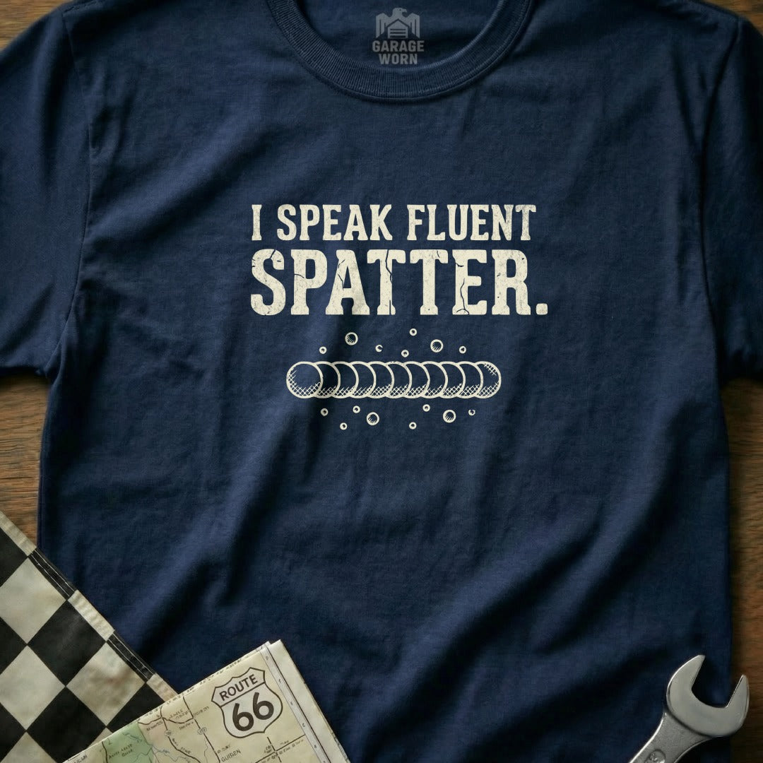 Navy t-shirt with "I SPEAK FLUENT SPATTER." text and weld bead graphic.