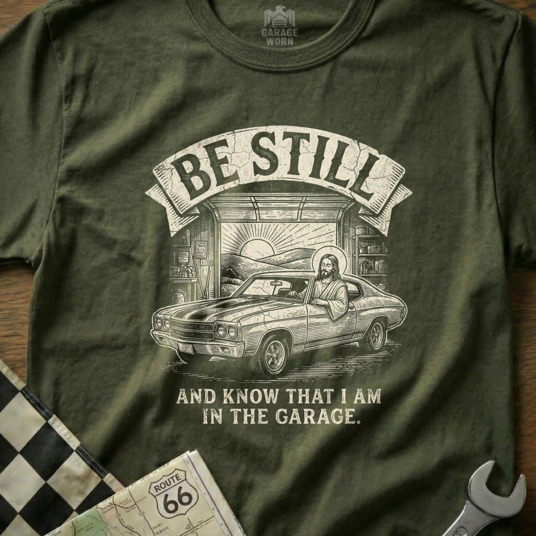 Jesus in a car with "Be Still" text, in a garage setting.