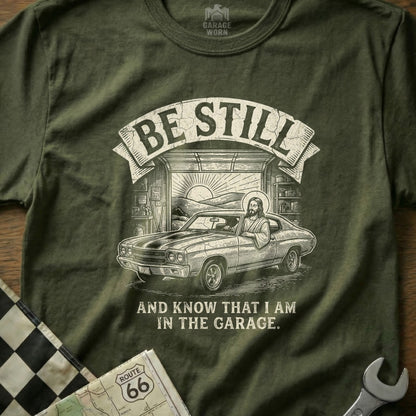 Jesus in a car with "Be Still" text, in a garage setting.