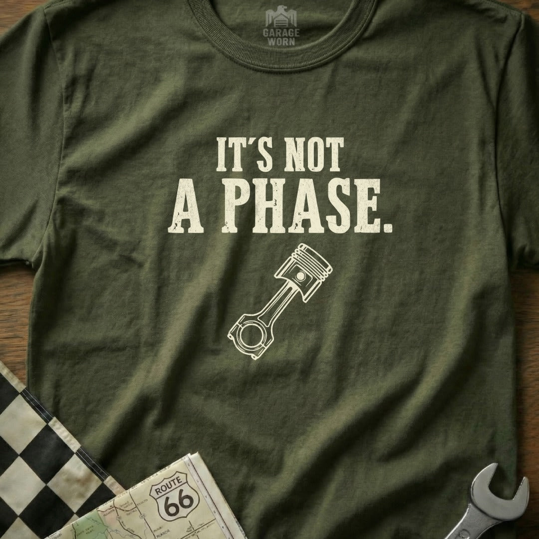 Olive green t-shirt with "It's NOT A PHASE." and a piston graphic.