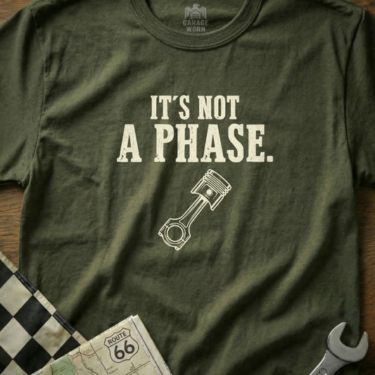 Olive green t-shirt with "It's NOT A PHASE." and a piston graphic.