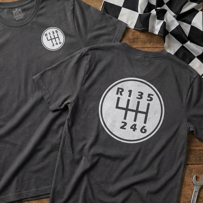 Dark gray t-shirt featuring a white six-speed manual transmission shift pattern graphic.