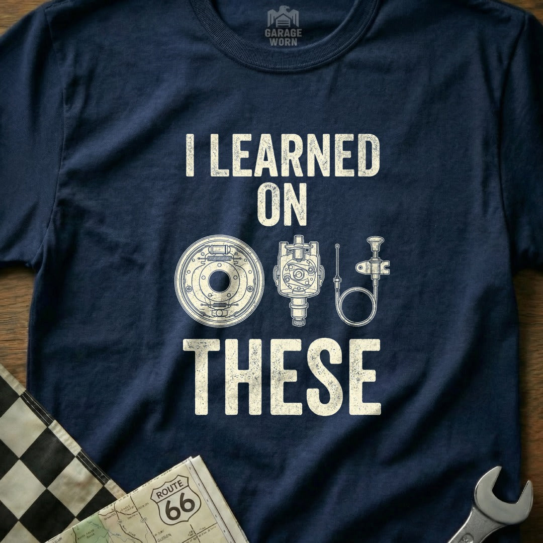 Navy t-shirt with "I LEARNED ON THESE" and mechanical parts graphic.