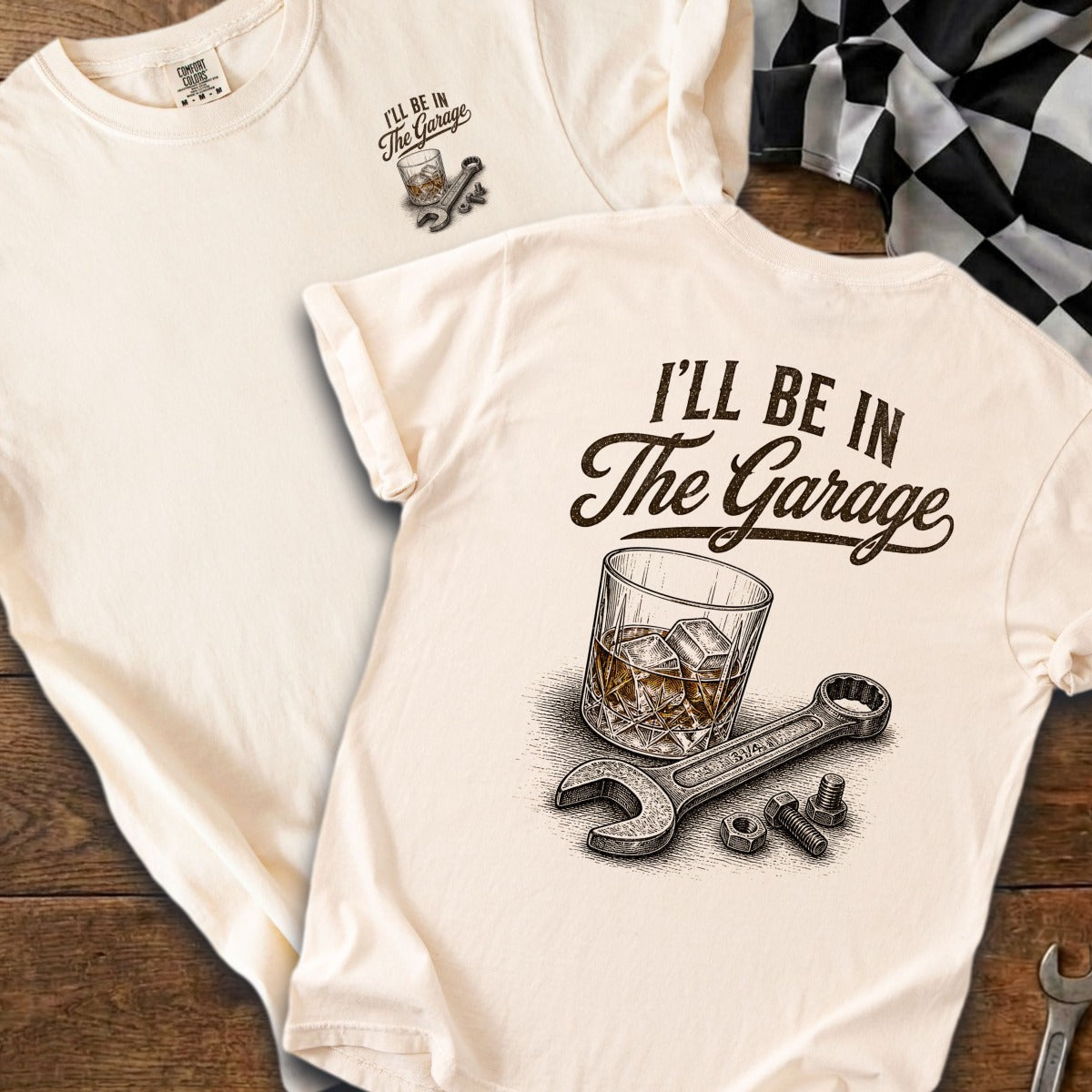 Cream shirt with "I'll Be In The Garage" text, whiskey glass, wrench, and bolts.