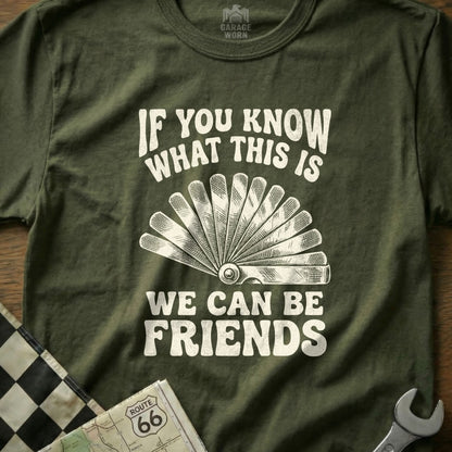 Olive green t-shirt with white text "If you know what this is We can be friends" and wrench graphic.