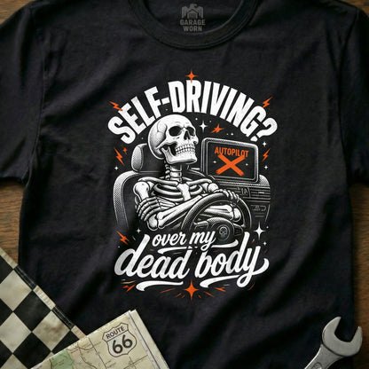 Black t-shirt graphic with skeleton driving, "Self-Driving? Over my dead body."