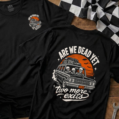 Black t-shirt with graphic of skeletons in a car and text "ARE WE DEAD YET".