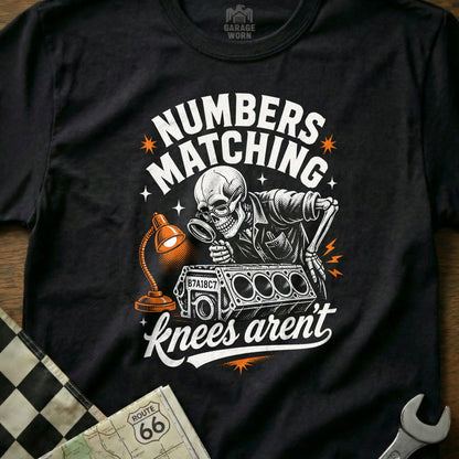 Skeleton with magnifying glass examining engine block, "NUMBERS MATCHING knees aren't".