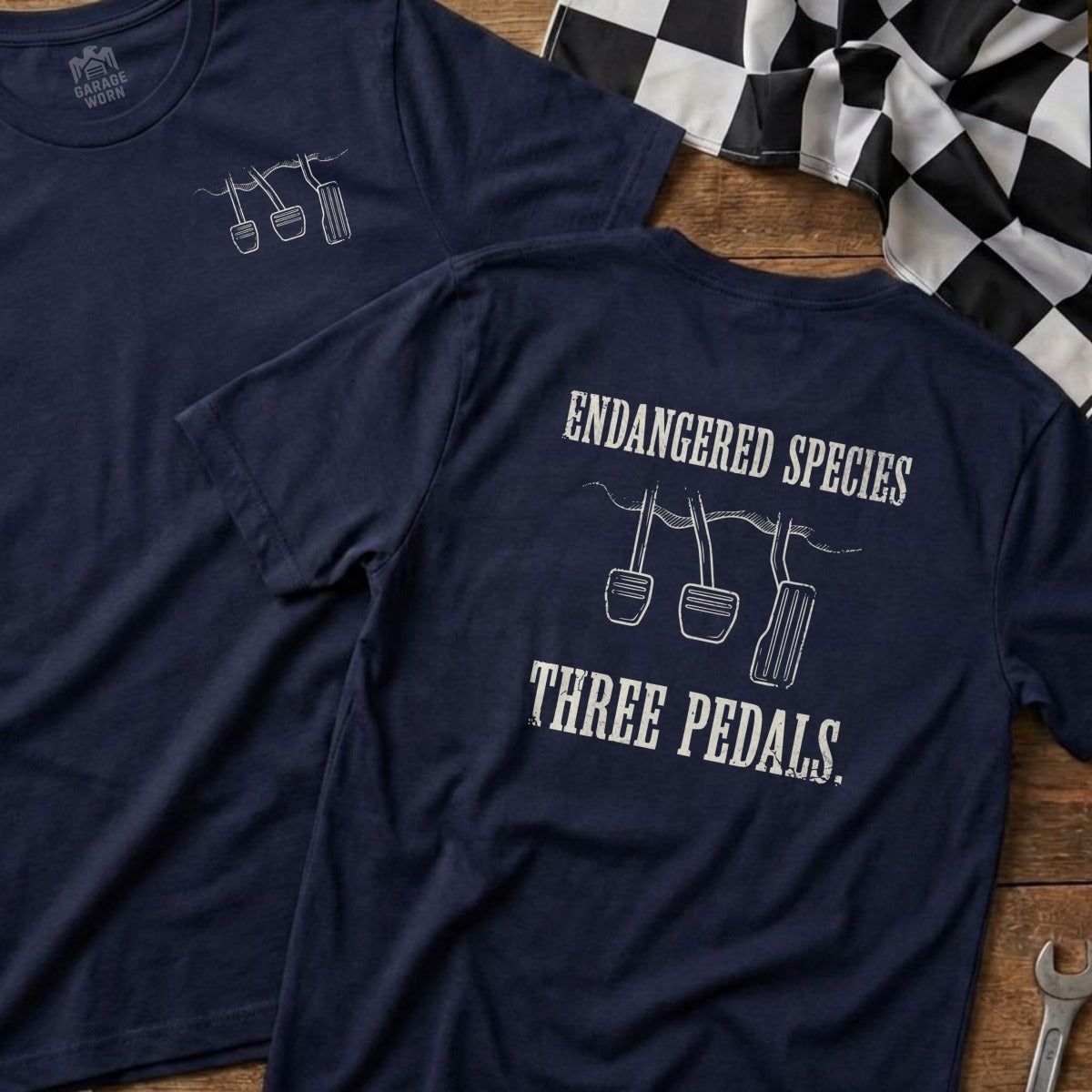 Navy t-shirt with "ENDANGERED SPECIES THREE PEDALS." graphic and pedal illustration.