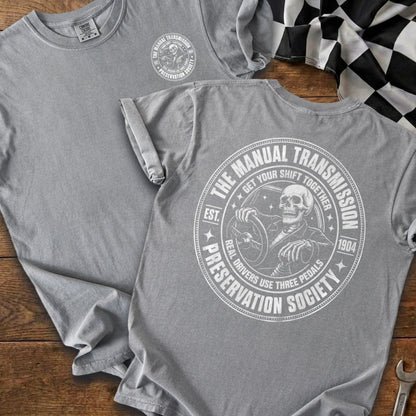 Grey t-shirt with "The Manual Transmission Preservation Society" circular graphic featuring a skeleton driving.