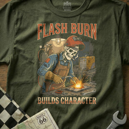 Skeleton welder with "Flash Burn Builds Character" text on olive green t-shirt.