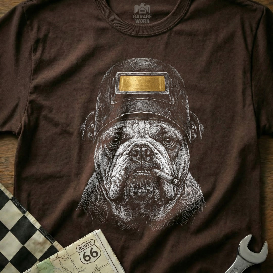 Bulldog wearing a welding mask and smoking a cigar on a brown t-shirt.