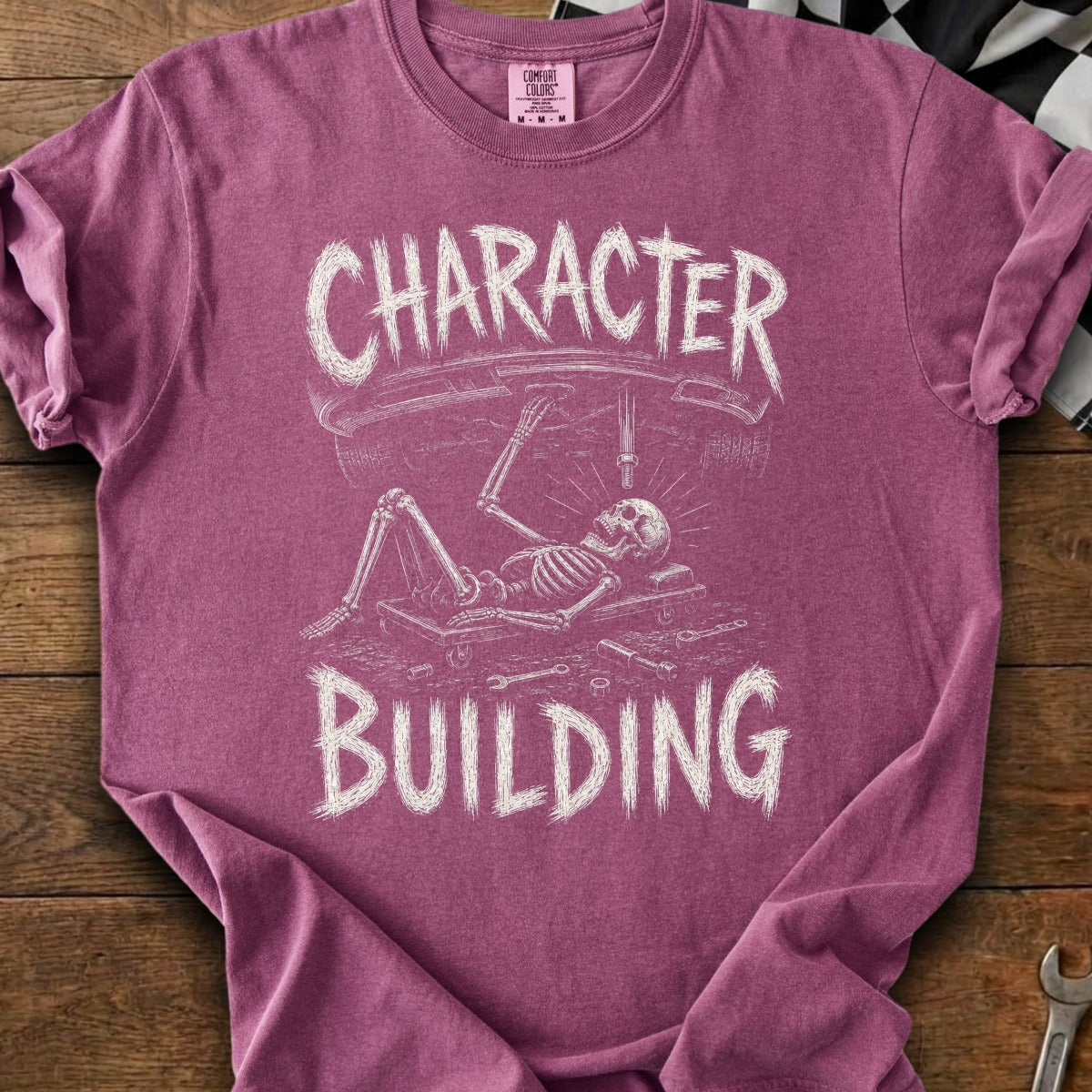 Skeleton working on car under the words Character Building.