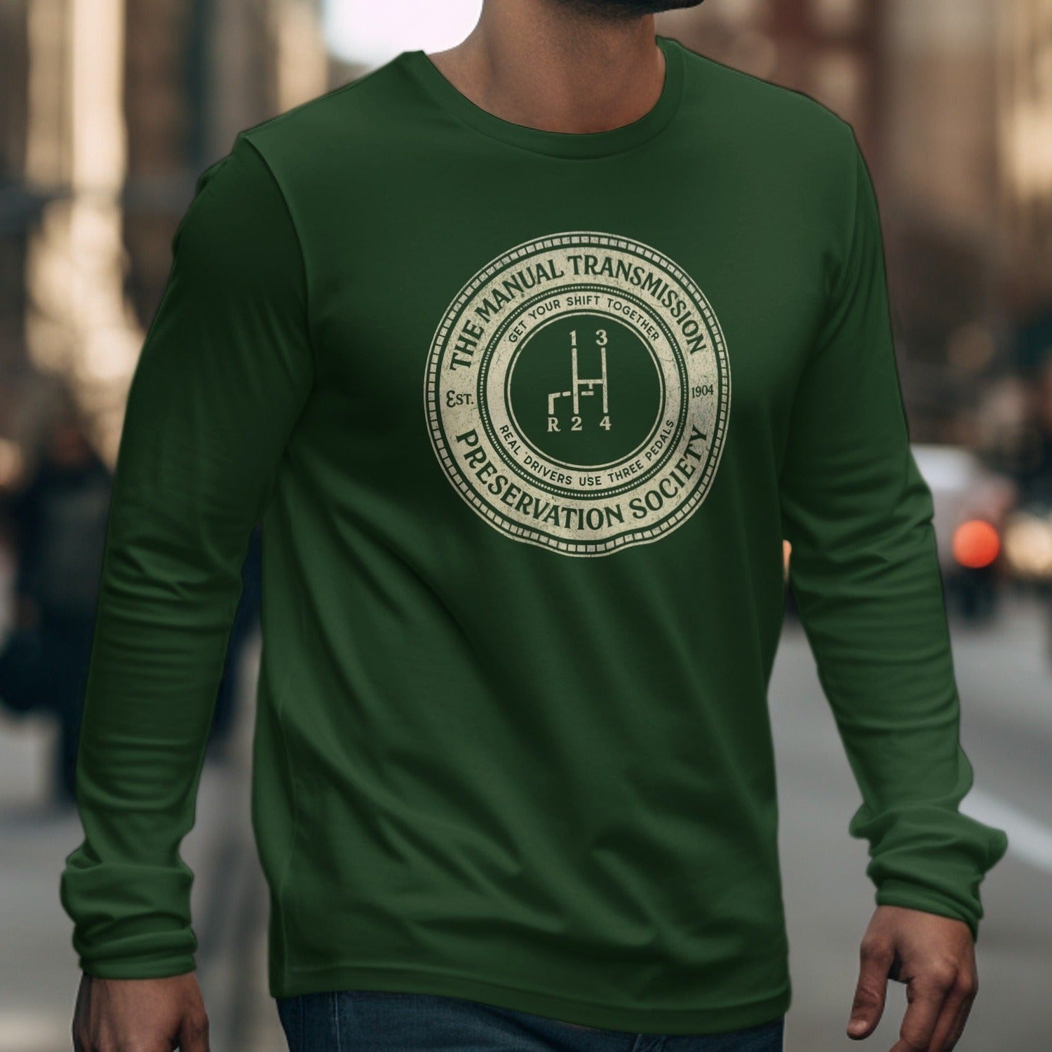 Green long-sleeve shirt with a circular graphic about manual transmissions and pedal use.