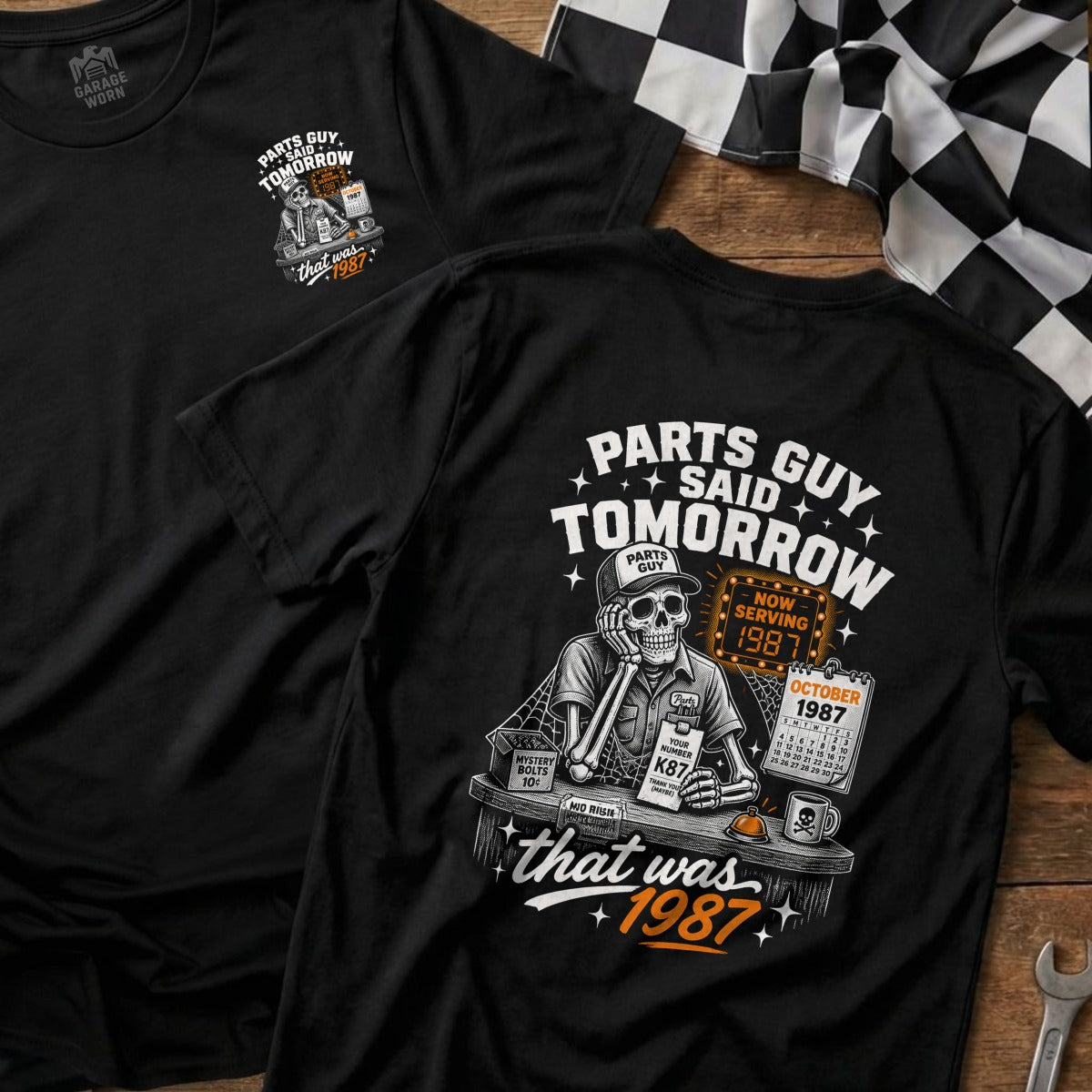 Black t-shirt graphic with skeleton, calendar, and "Parts Guy Said Tomorrow, That Was 1987".